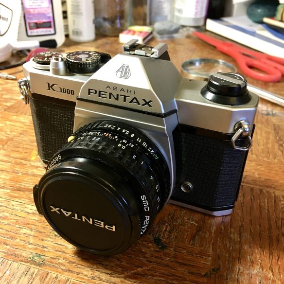A black and silver, vintage Asahi Pentax K1000 35mm camera, manufactured in the early 1980s. 